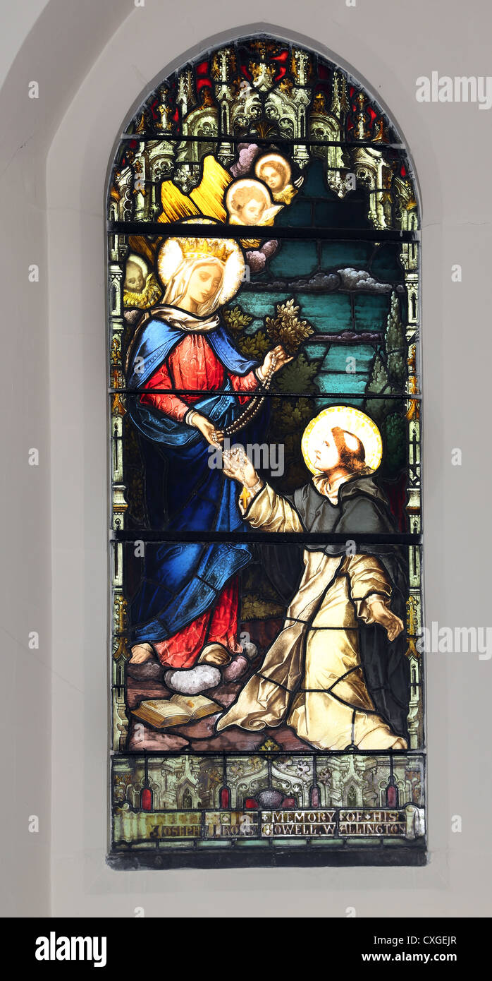 Surrey, Inglaterra Sutton Iglesia de Nuestra Señora del Rosario, Vidriera de la Virgen María dando el rosario a Santo Domingo Foto de stock