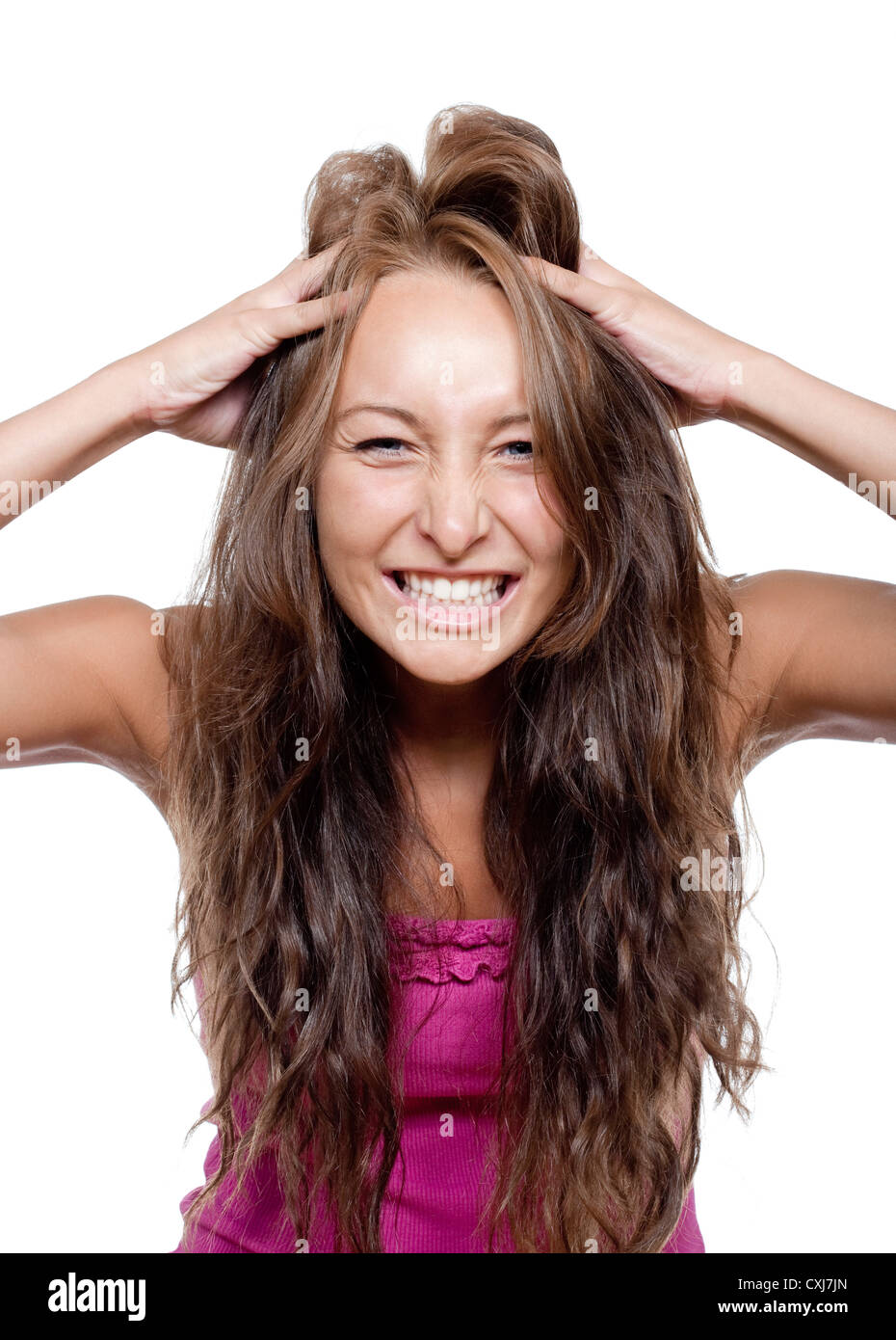 Mujer joven girando los dedos por su cabello haciendo una cara Foto de stock