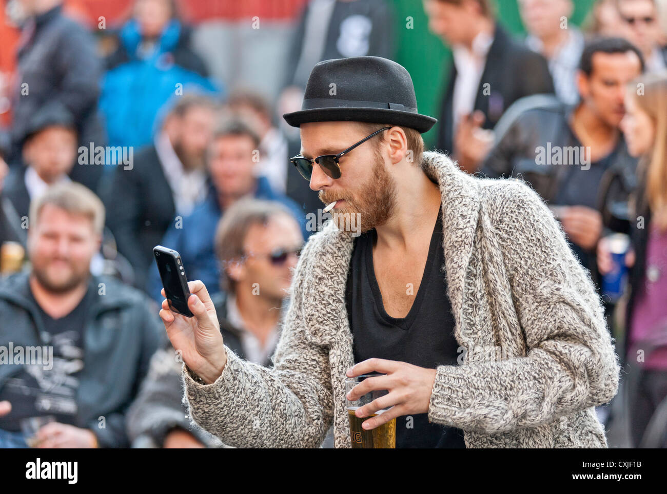Utilizando un teléfono inteligente para tomar una fotografía, festival de verano, Reykjavik, Iceland Foto de stock
