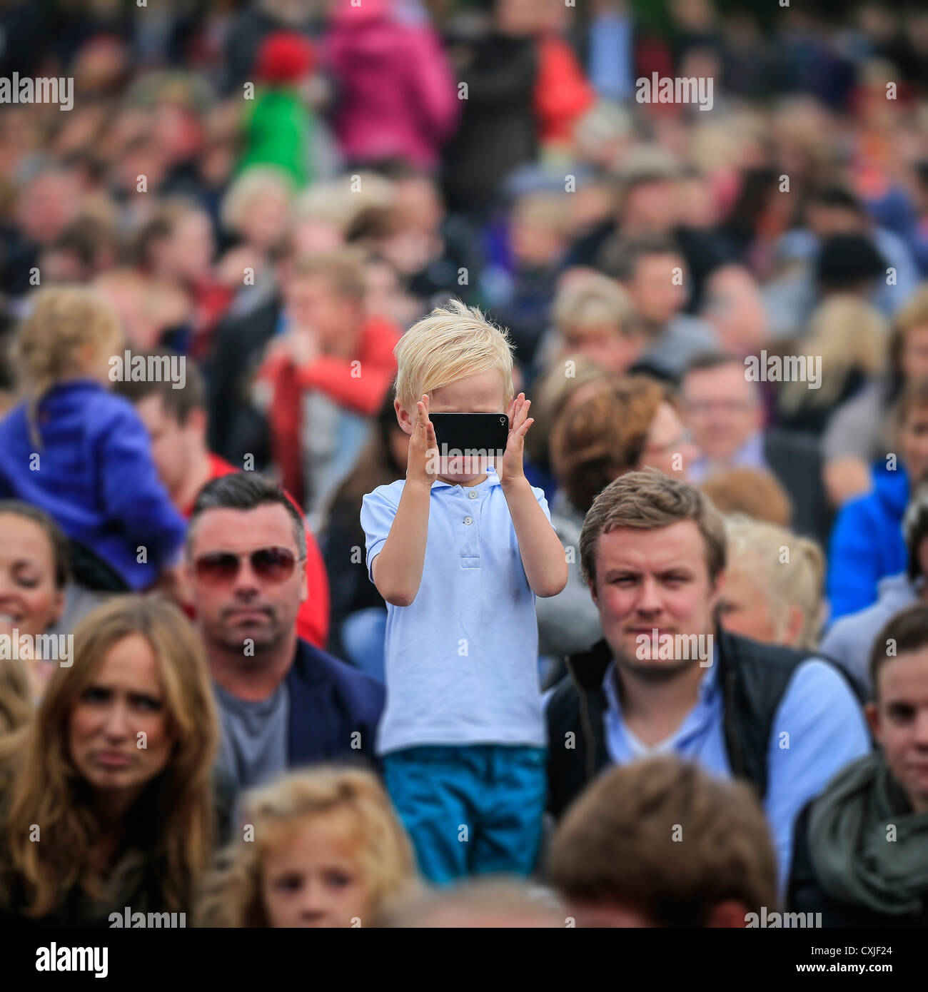 Joven con un teléfono inteligente para tomar una fotografía, concierto gratuito en el parque "de monstruos y hombres" en Reikiavik, Islandia Foto de stock