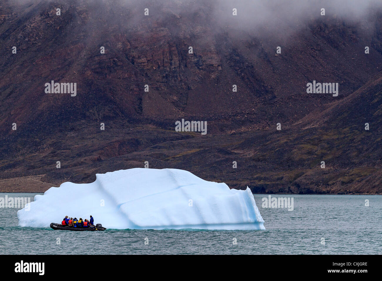 Zodiac con turistas costas por pequeños iceberg en Nunavut, Canadá. Verano Ártico alto. Foto de stock