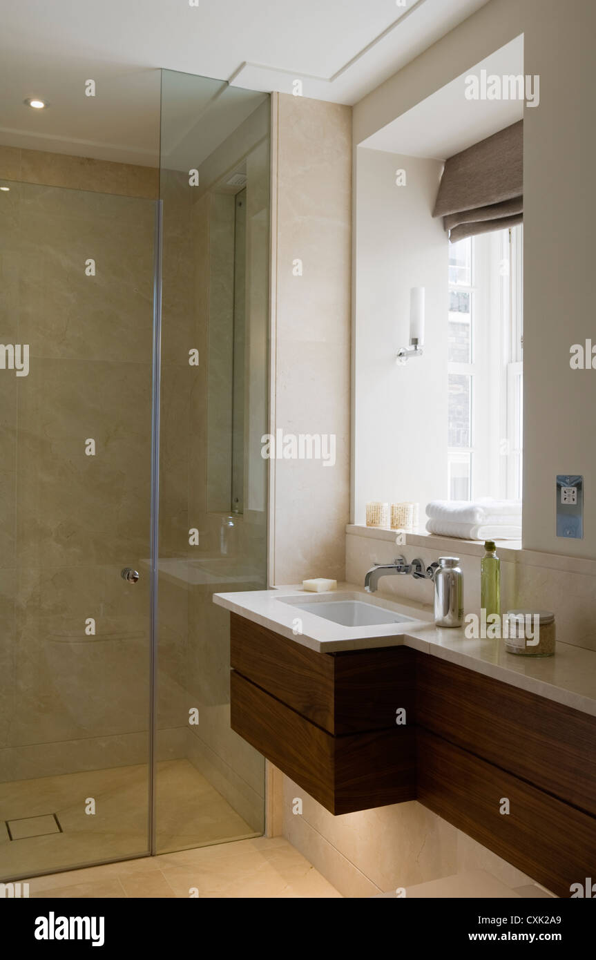 Cuarto de baño interior color lavabo tocador masculino persianas ciegas romano cubículo de ducha de vidrio ventanal mármol Foto de stock
