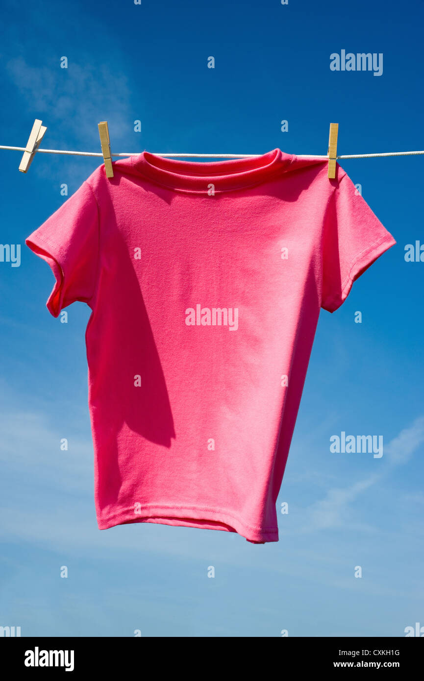 Una camiseta rosada colgando de un tendedero en un hermoso día soleado,  agregar texto o gráfico a camisas o espacio de copia Fotografía de stock -  Alamy