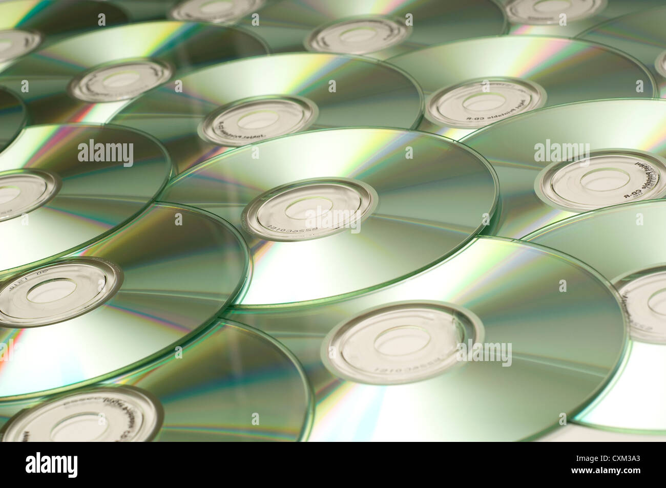 Una pila de varios discos compactos por una tecnología de fondo... Foto de stock