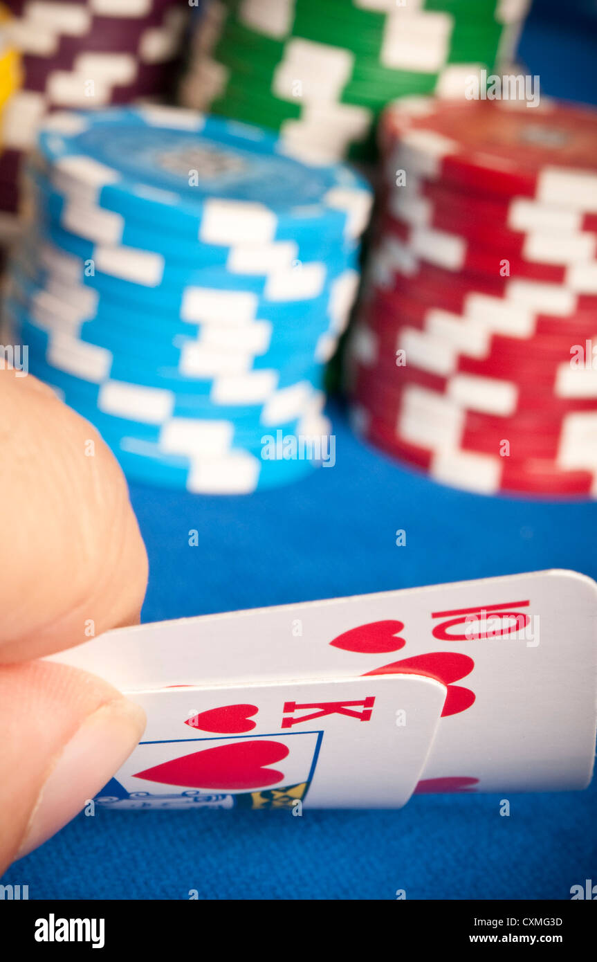 Mano de un hombre mirar propias tarjetas, durante un juego de póquer Texas Holdem Foto de stock