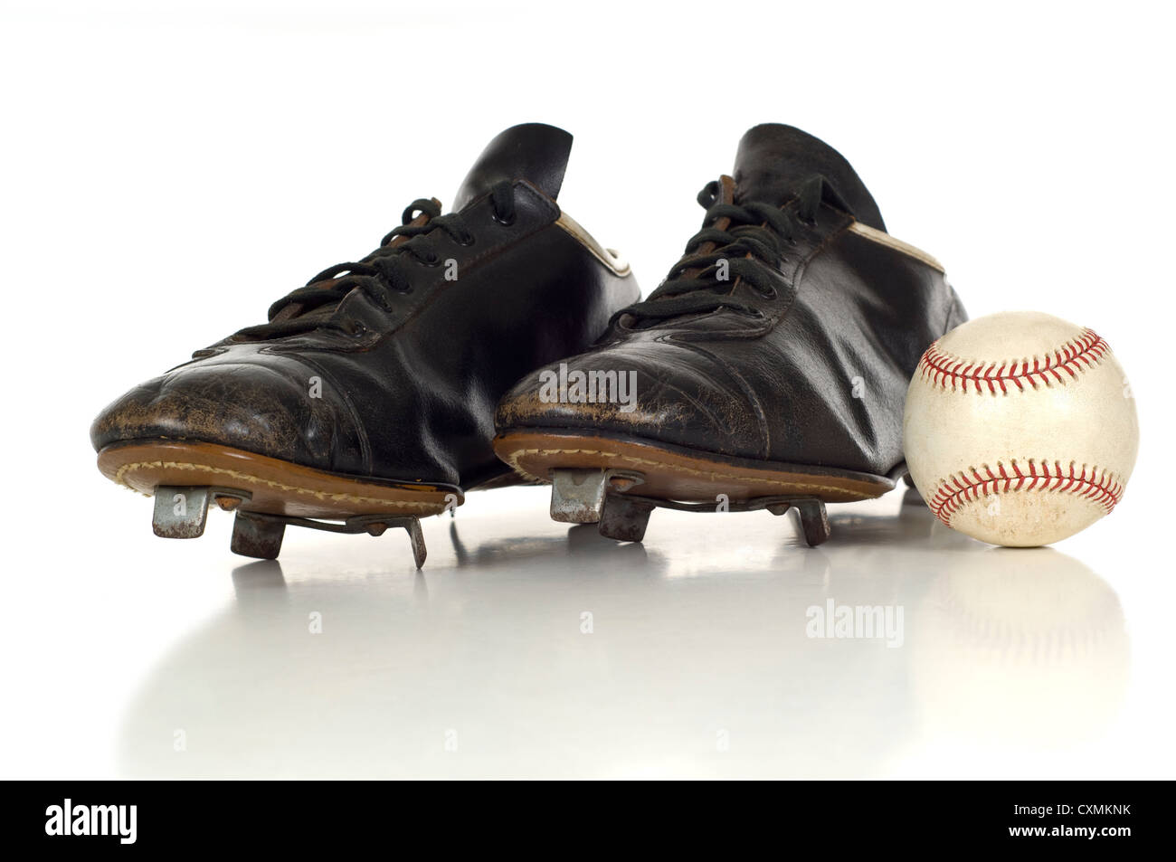 Un par de antigüedades de cuero negro, vintage baseball zapatos con una  pelota de béisbol sobre un fondo blanco Fotografía de stock - Alamy