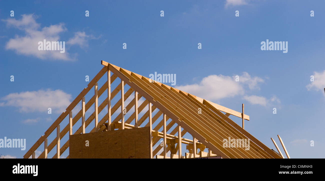 Casa nueva en construcción con madera, vigas y suministros Foto de stock
