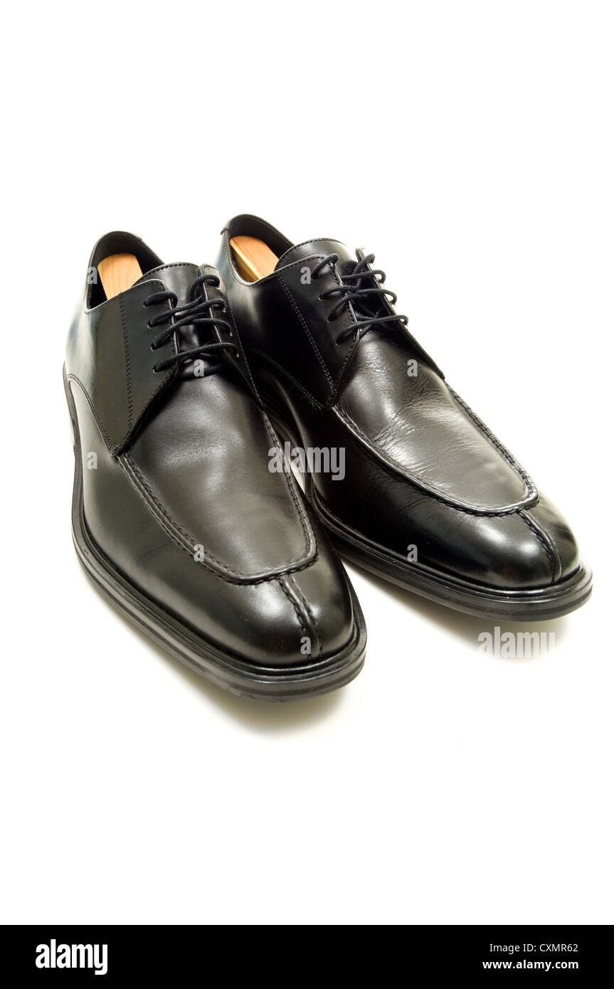 Zapatos negros de hombre de vestir clásico con cordones sobre un fondo  blanco liso y aislado. Vista de frente y de cerca. Copy space foto de Stock