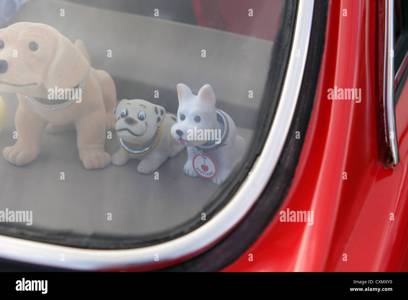 Kitsch perros asintiendo con la cabeza en la bandeja trasera del coche  clásico rojo, cerca de la fotografía Fotografía de stock - Alamy