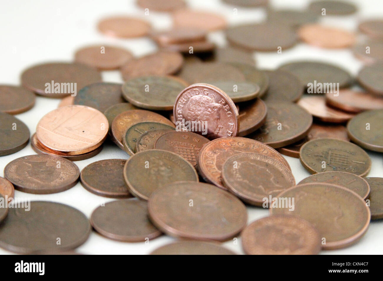 Moneda de 1 céntimo brillante entre otras monedas de cobre en el REINO UNIDO Foto de stock