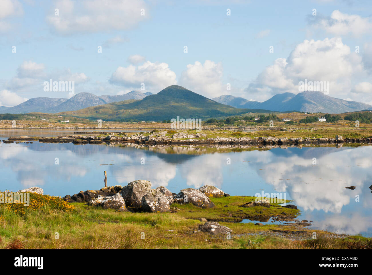 Los pintorescos lagos y montañas de Connemara, Condado de Galway, Irlanda, con nubes y montañas reflejadas en el lago Foto de stock