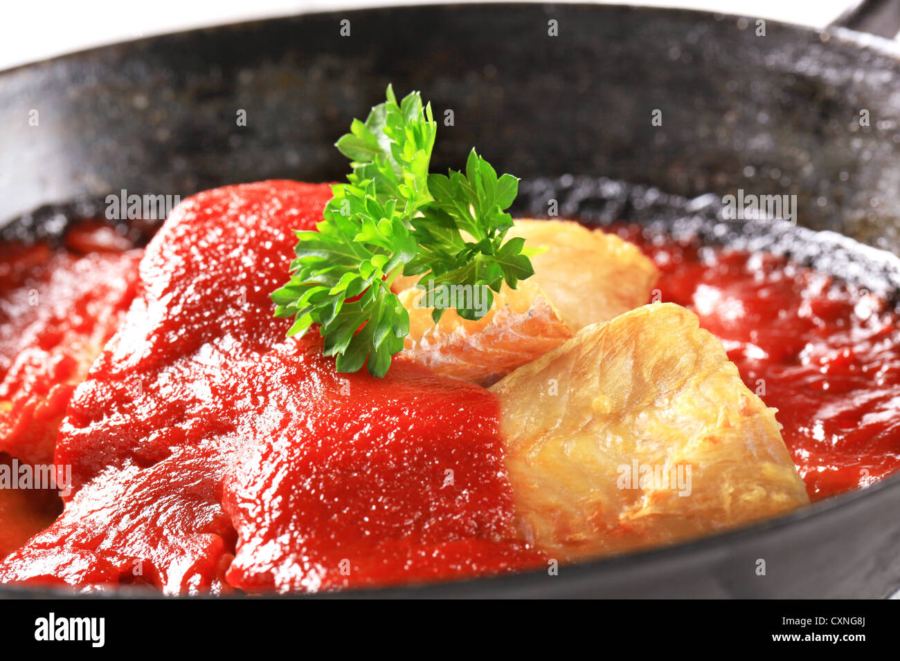 Sartén filetes de pescado en salsa de tomate rico Foto de stock