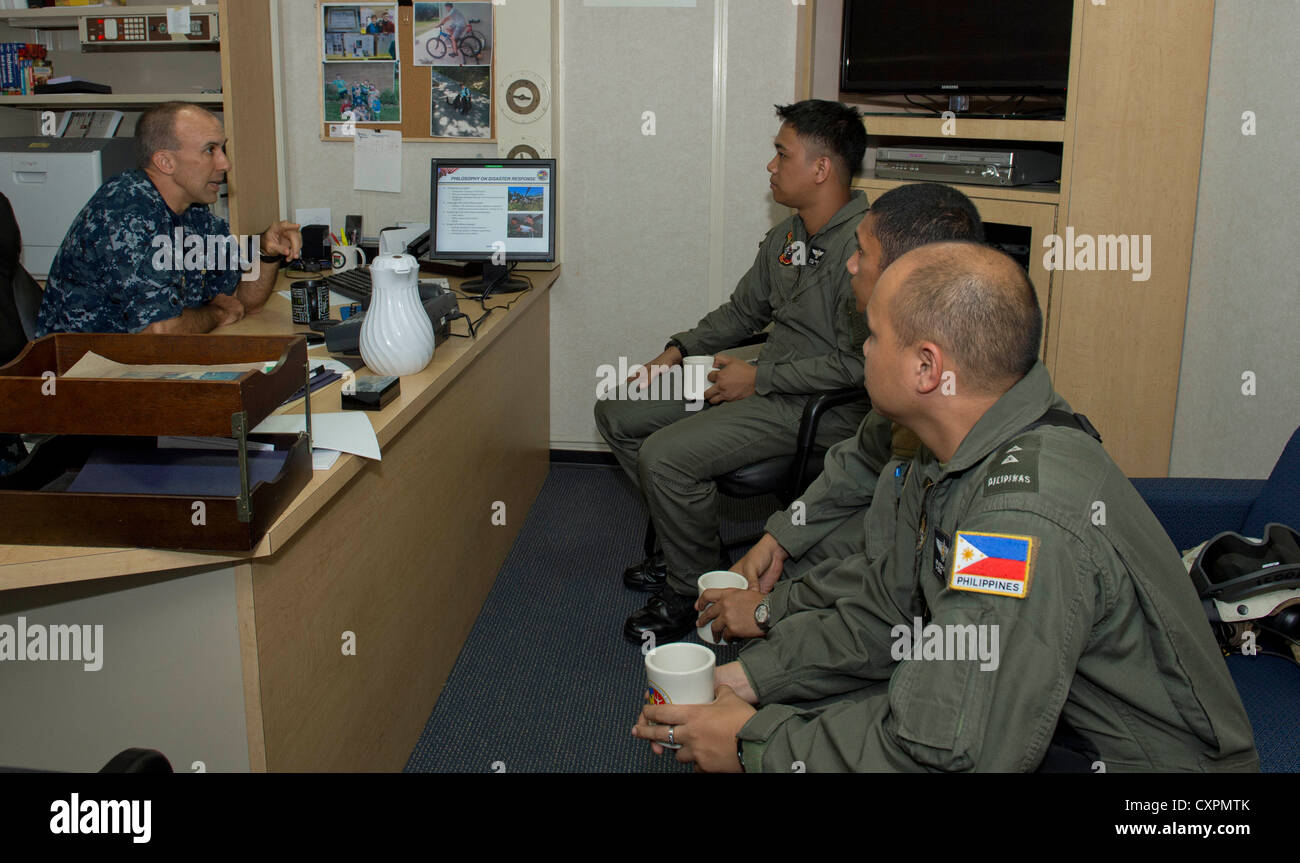 Capt. cathal o'connor, comandante de escuadrón anfibio 11, habla con los miembros de las fuerzas armadas de Filipinas a bordo del buque de asalto anfibio USS Bonhomme Richard (LHD 6). El Bonhomme Richard Amphibious Ready Group, junto con la 31ª unidad expedicionaria de los infantes de marina, están participando en el ejercicio anfibio, que es un ejercicio bilateral anual celebrado en conjunción con la AFP. Bonhomme Richard, comandada por el capitán Daniel dusek, es la derivación del buque sólo desplegadas Amphibious Ready Group y opera actualmente en los EE.UU. 7ª flota área de responsabilidad. Foto de stock