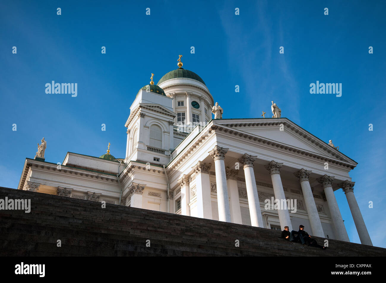 Pareja Sentada en los escalones en frente de la Catedral de Helsinki en la Plaza del Senado, Helsinki, Finlandia Foto de stock