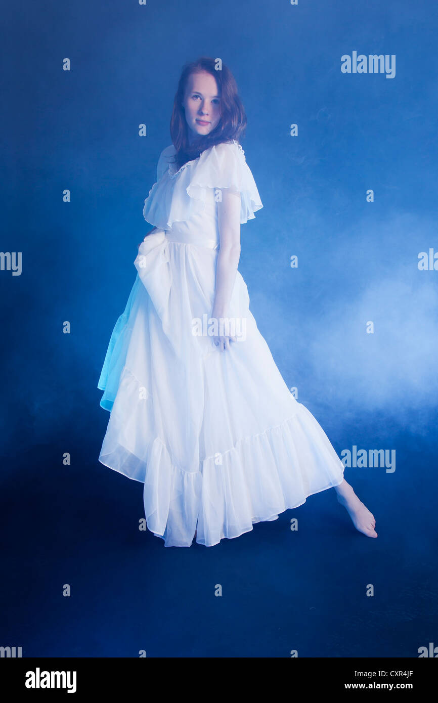 Una joven novia de traje de novia y bailando en piso humo azul de ella Fotografía de stock - Alamy