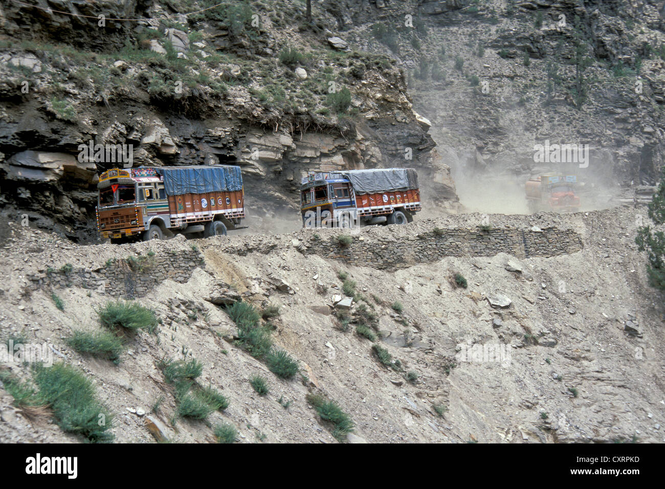 Camiones circulando en una carretera polvorienta propensa a los deslizamientos, Manali Leh la autopista Proximidad Keylong o Kyelang, Himahal Pradesh Foto de stock