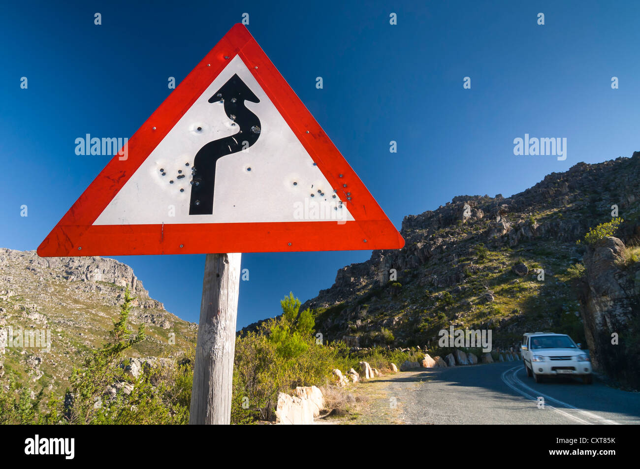 Disparo señales de carretera, carretera sinuosa, el coche en la carretera, Western Cape, Sudáfrica, África Foto de stock