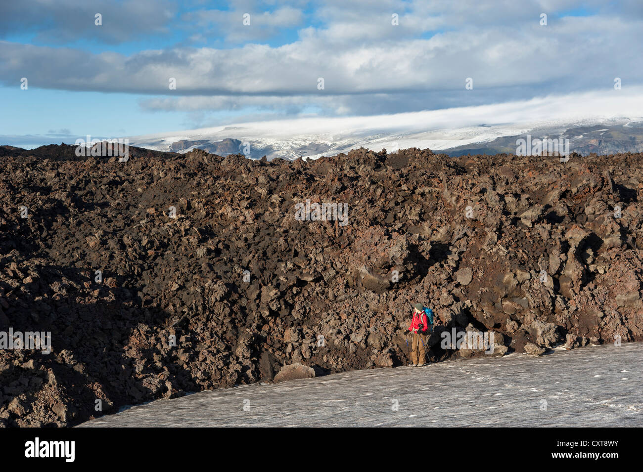 Excursionista de pie junto al flujo de lava solidificada, Godahraun Goðahraun, campo de lava en el volcán Fimmvoerðuháls, sendero a Foto de stock