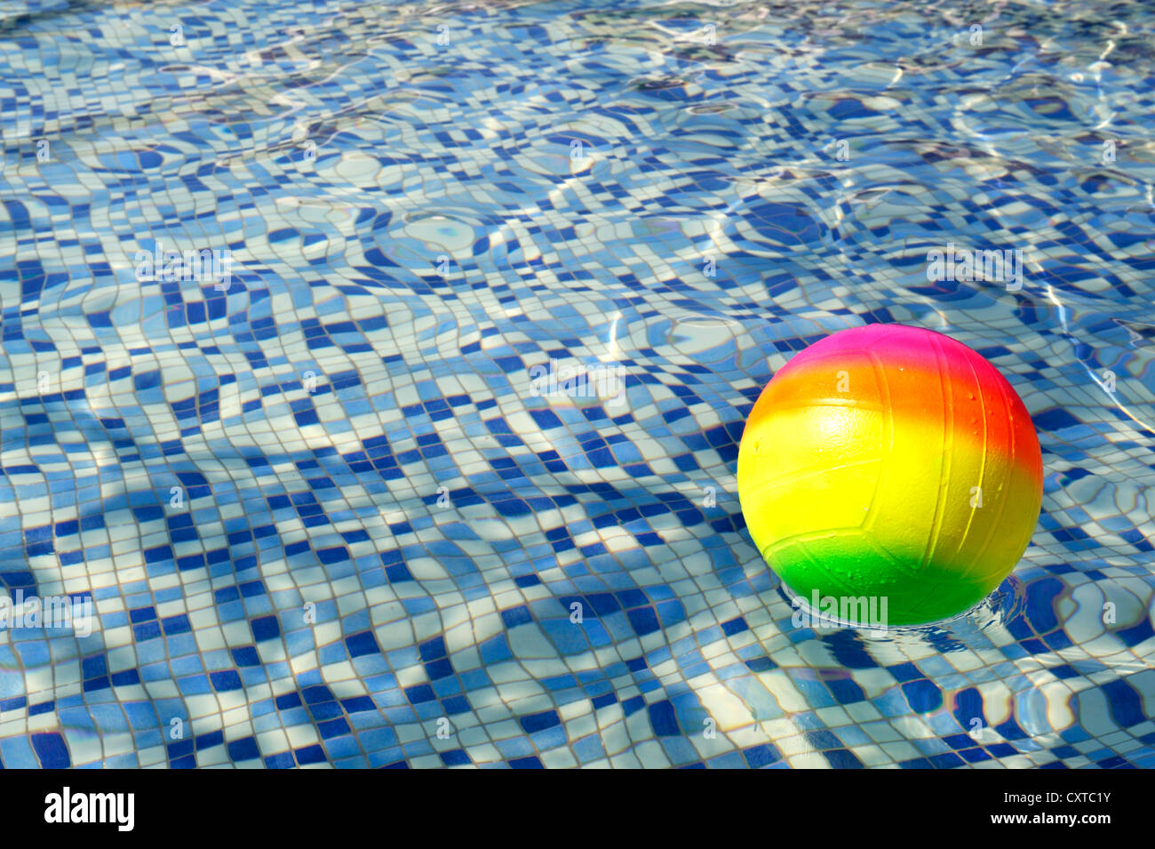 Colorida pelota flotando sobre el agua Foto de stock