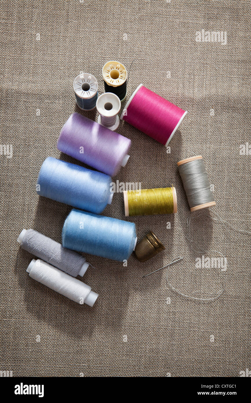 Hilo de coser, aguja y dedal Foto de stock