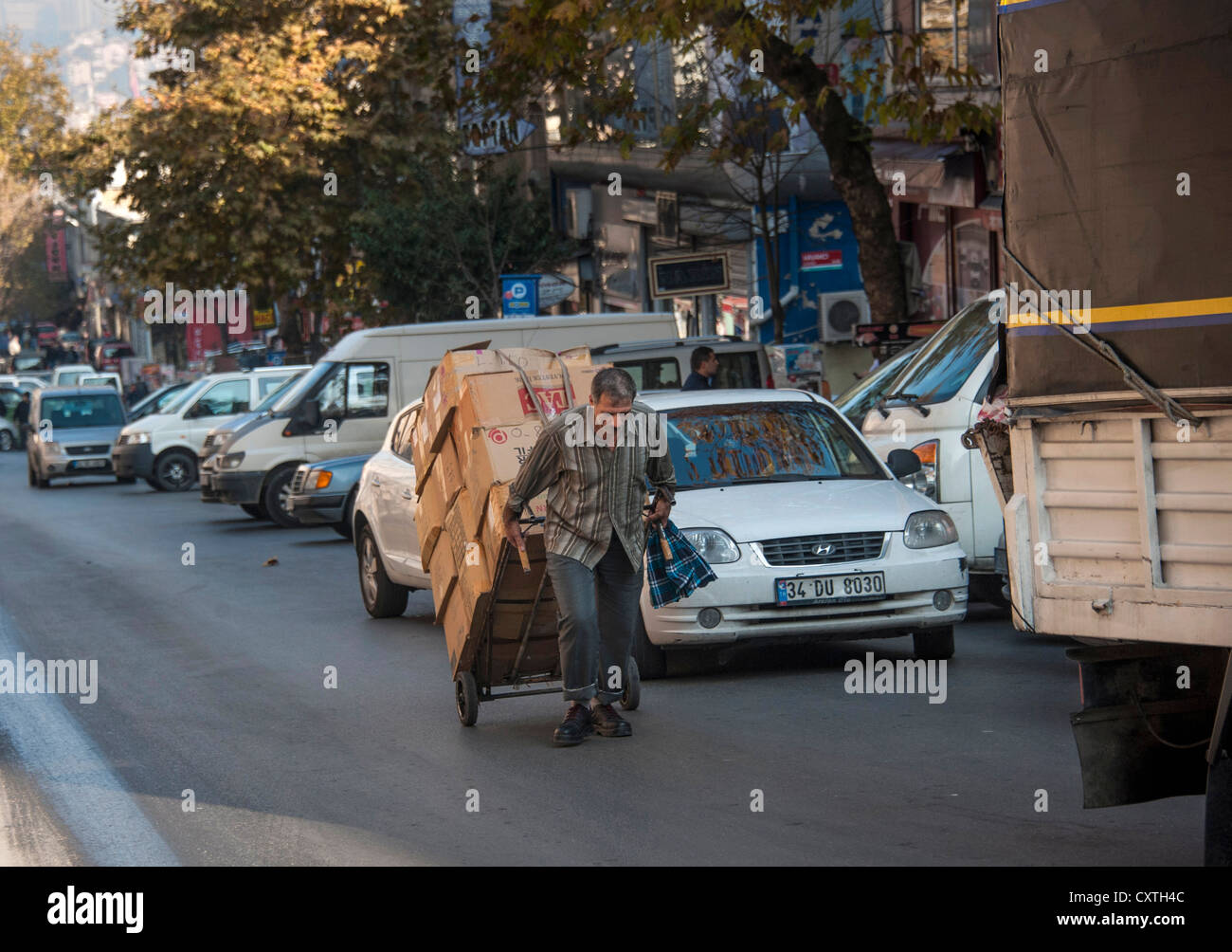 Hombre con una carretilla llena de paquetes en una calle de Estambul Foto de stock
