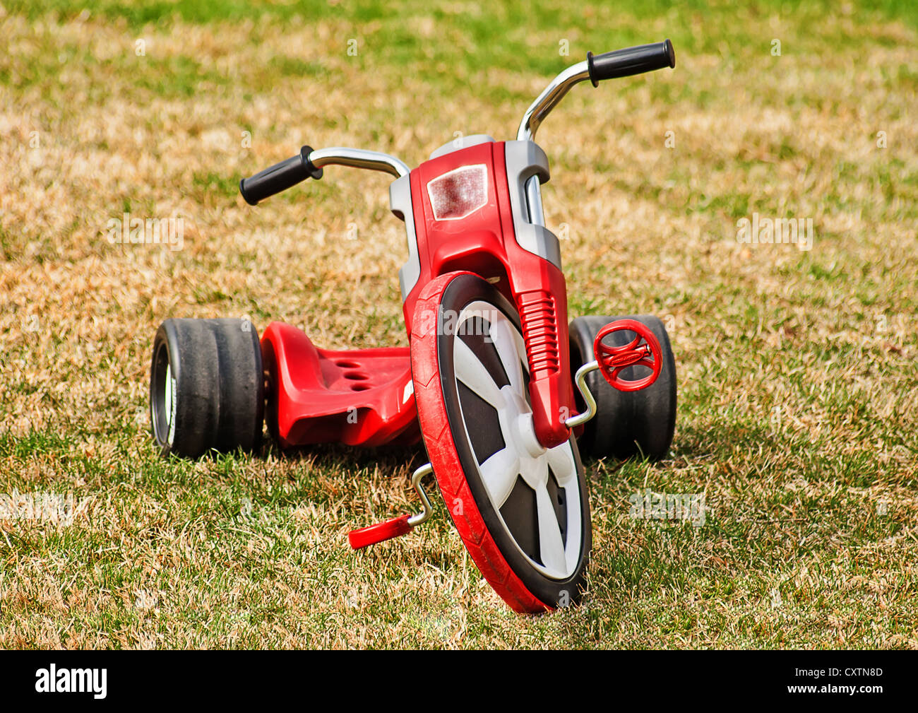 Triciclo de rueda grande rojo brillante para un niño pequeño para  divertirnos Fotografía de stock - Alamy