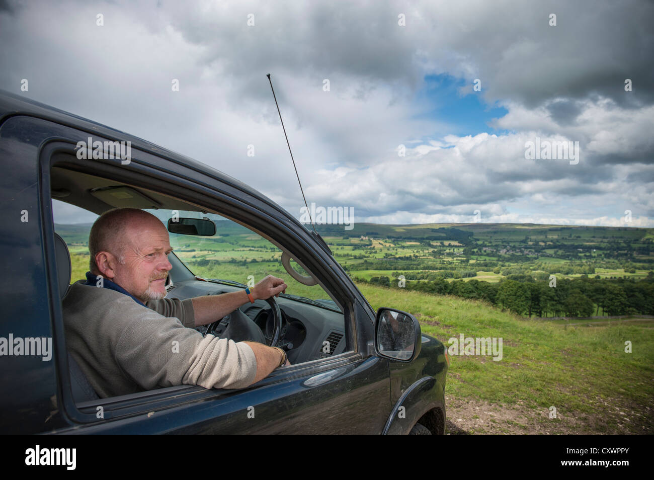 El hombre la conducción de automóviles en el paisaje rural Foto de stock