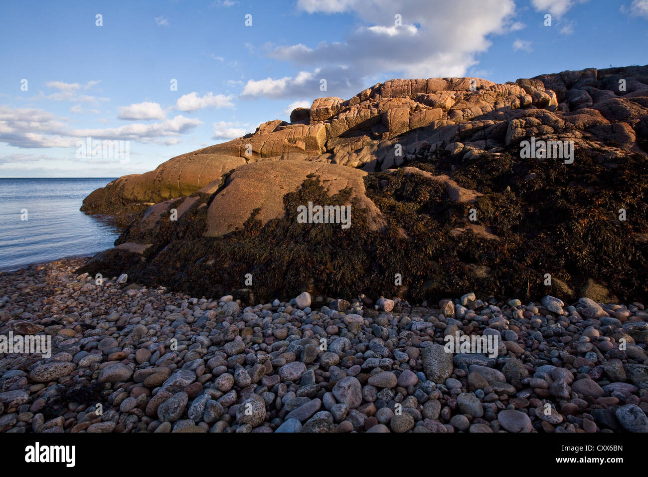 El sol se pone en la rocosa costa y de la zona intermareal del río San Lorenzo en Essipit y Les Escoumins en Quebec Foto de stock