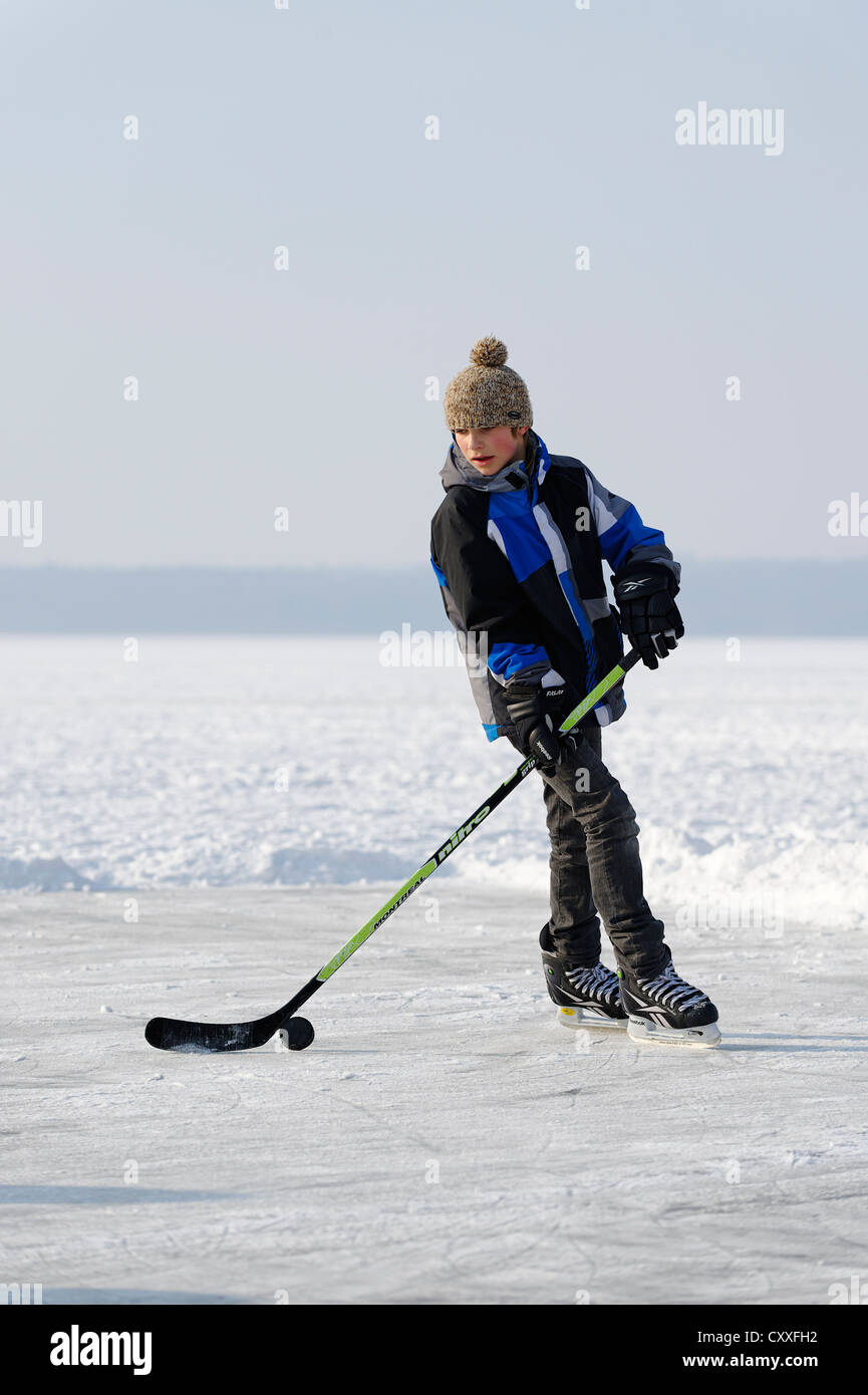 Boy jugar hockey sobre hielo, cerca de St. Heinrich, el Lago Starnberg, cinco lagos, Alta Baviera, Baviera Foto de stock