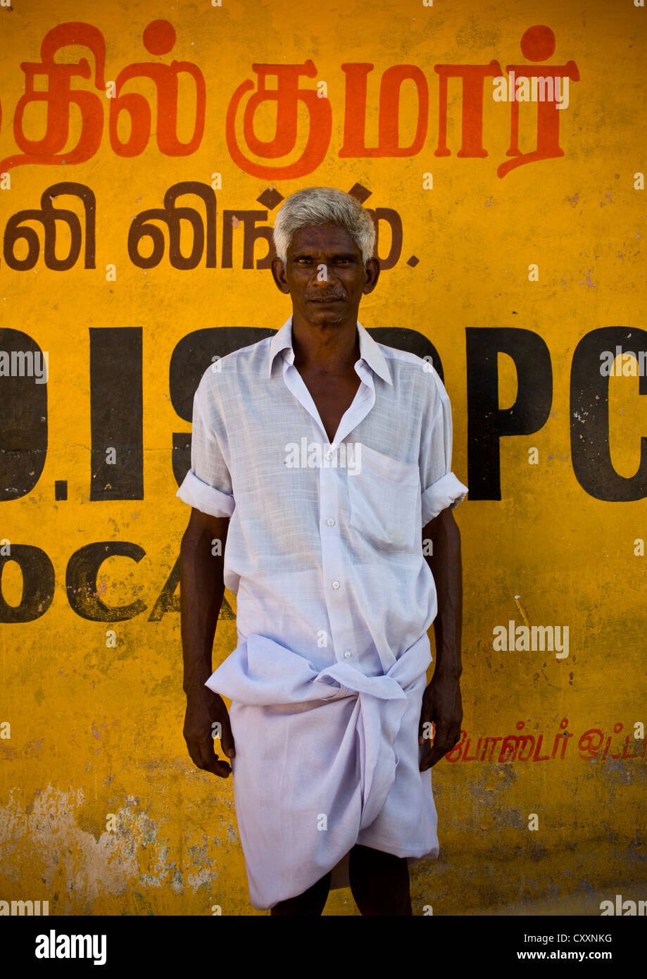 Hombre indio con canas y una camisa blanca posando delante de una pared amarilla, Periyar, India Foto de stock