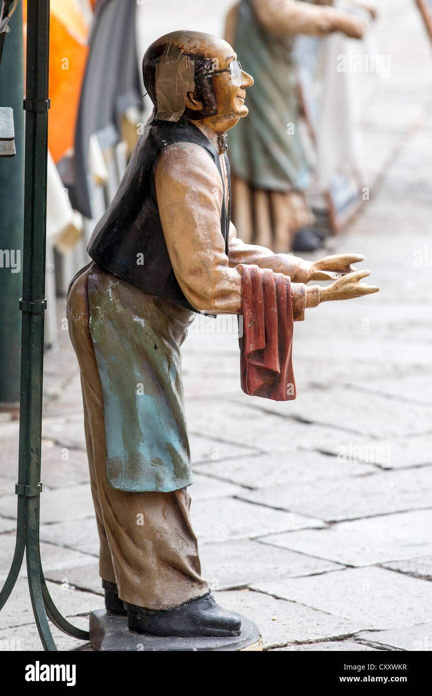 Una estatuilla de yeso de un camarero, el uso de un delantal y sosteniendo  una toalla, pero con su bandeja faltantes, fuera de una jaula en Venecia  Fotografía de stock - Alamy
