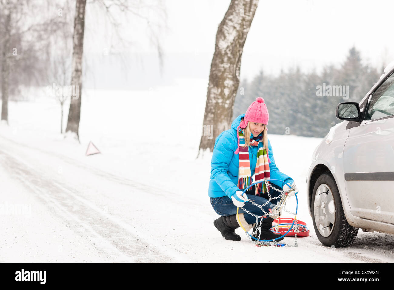 Cadenas para neumáticos de nieve invierno alquiler de mujer con desglose Fotografía de stock - Alamy