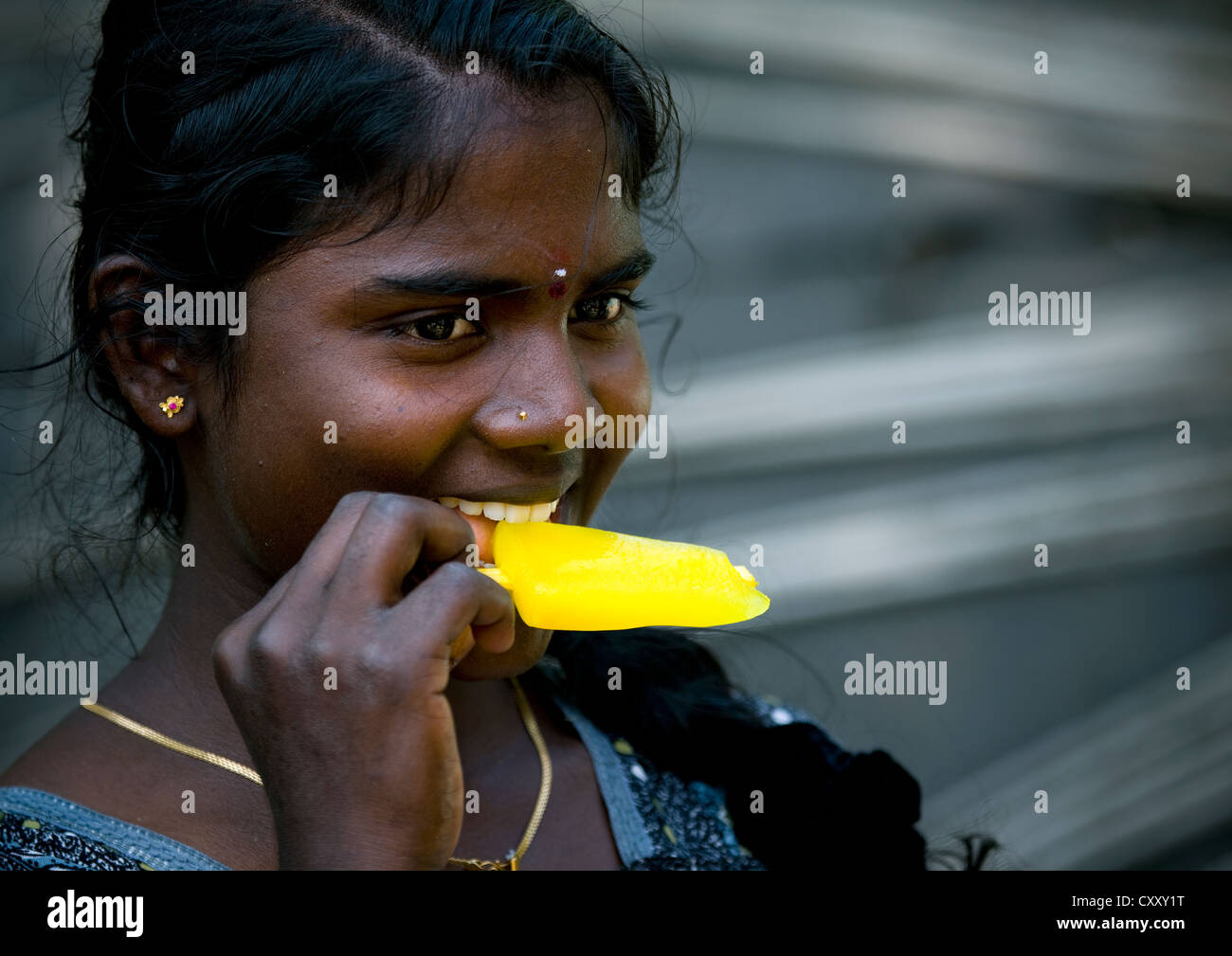 Muchacha con piercing en la nariz comiendo un helado, Mahabalipuram, India Foto de stock