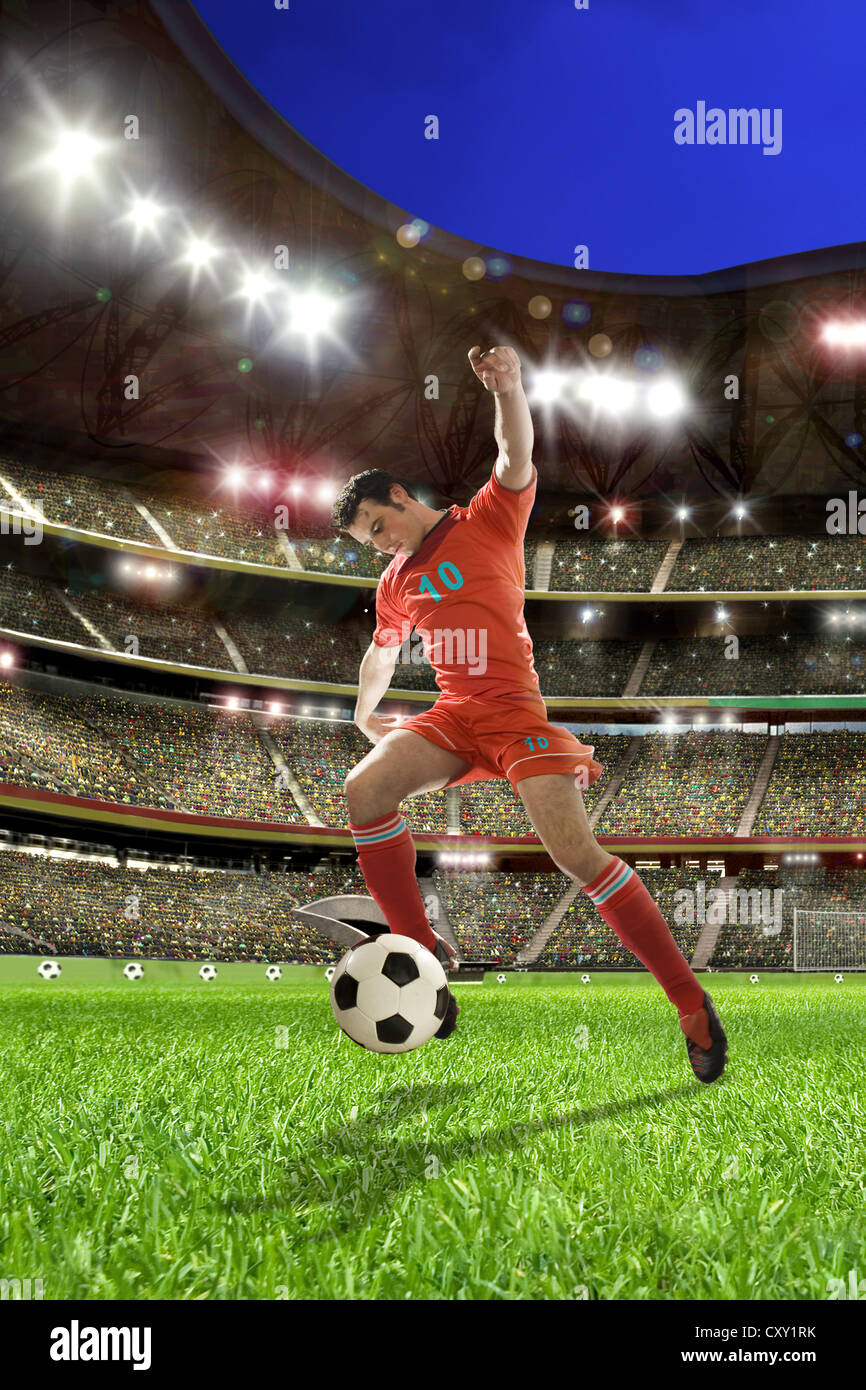 Jugador de fútbol pateando una pelota de fútbol, el estadio de fútbol Foto de stock