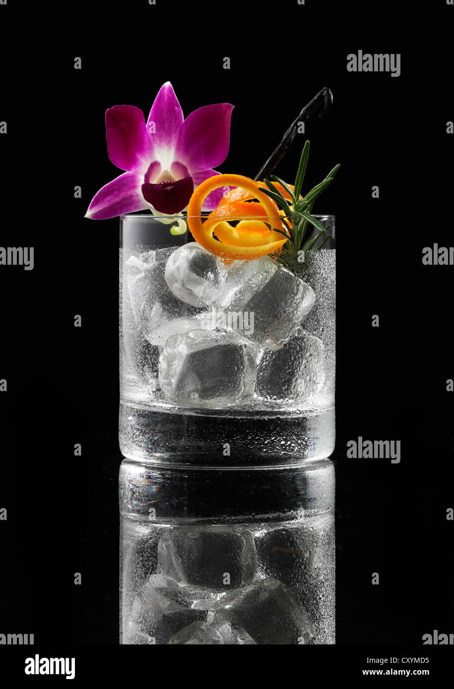Cristal preparado para un cóctel con cubitos de hielo y decoraciones Foto de stock