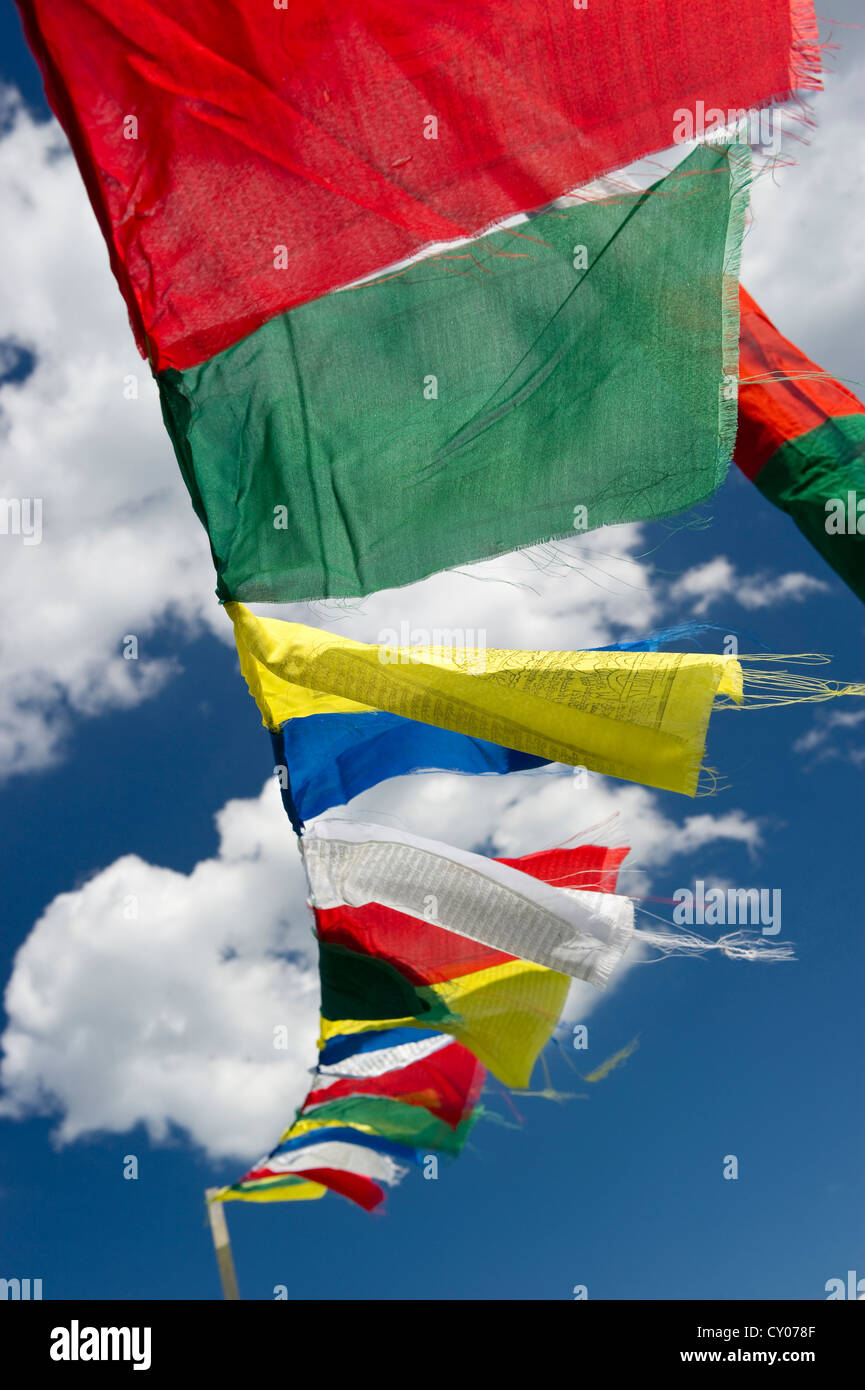 Banderas de oración tibetano contra un cielo azul con nubes Foto de stock