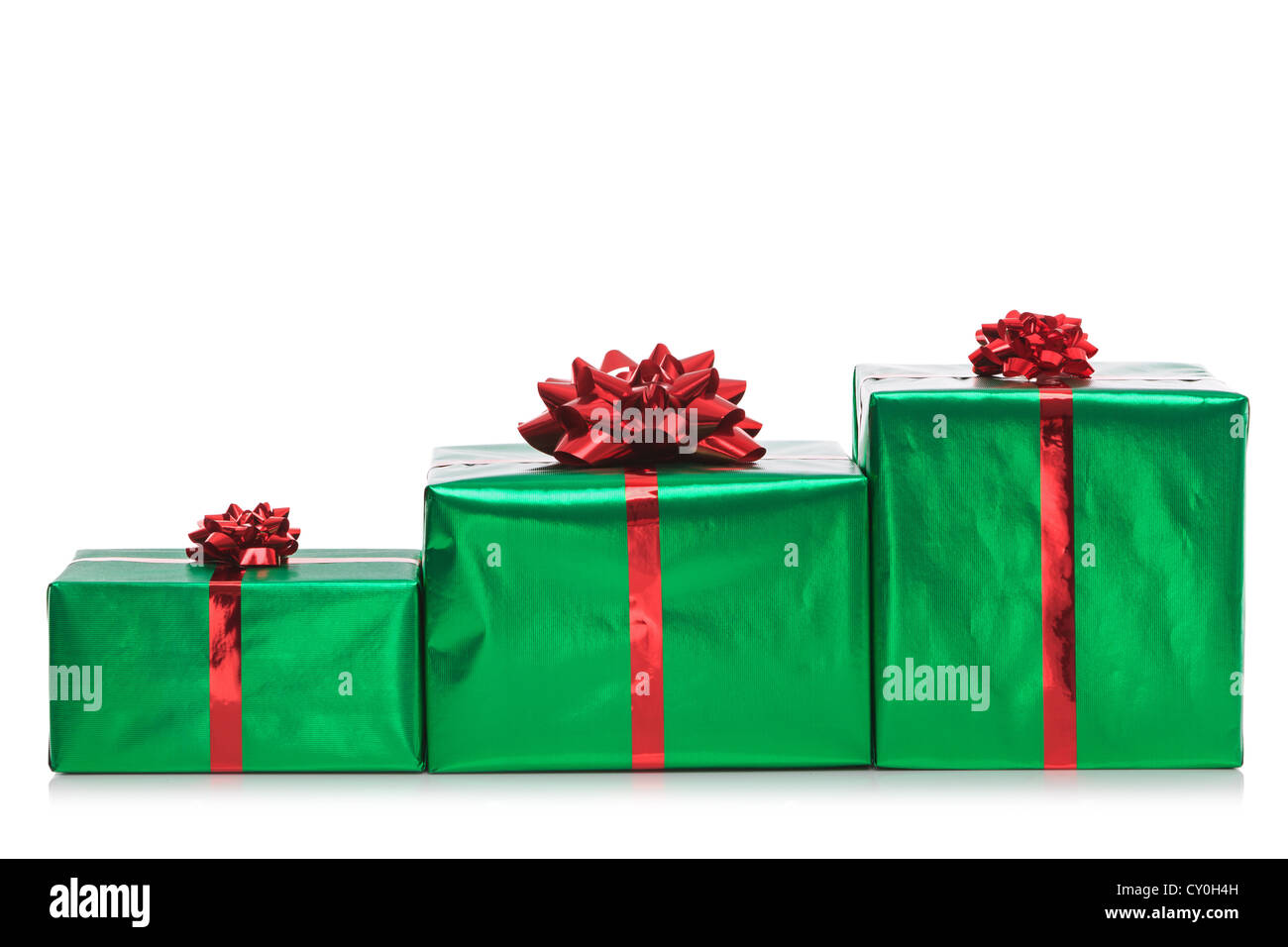 Tres Gift Wrapped presenta en verde papel de envolver con lazo rojo y cinta, aislado en un fondo blanco. Foto de stock
