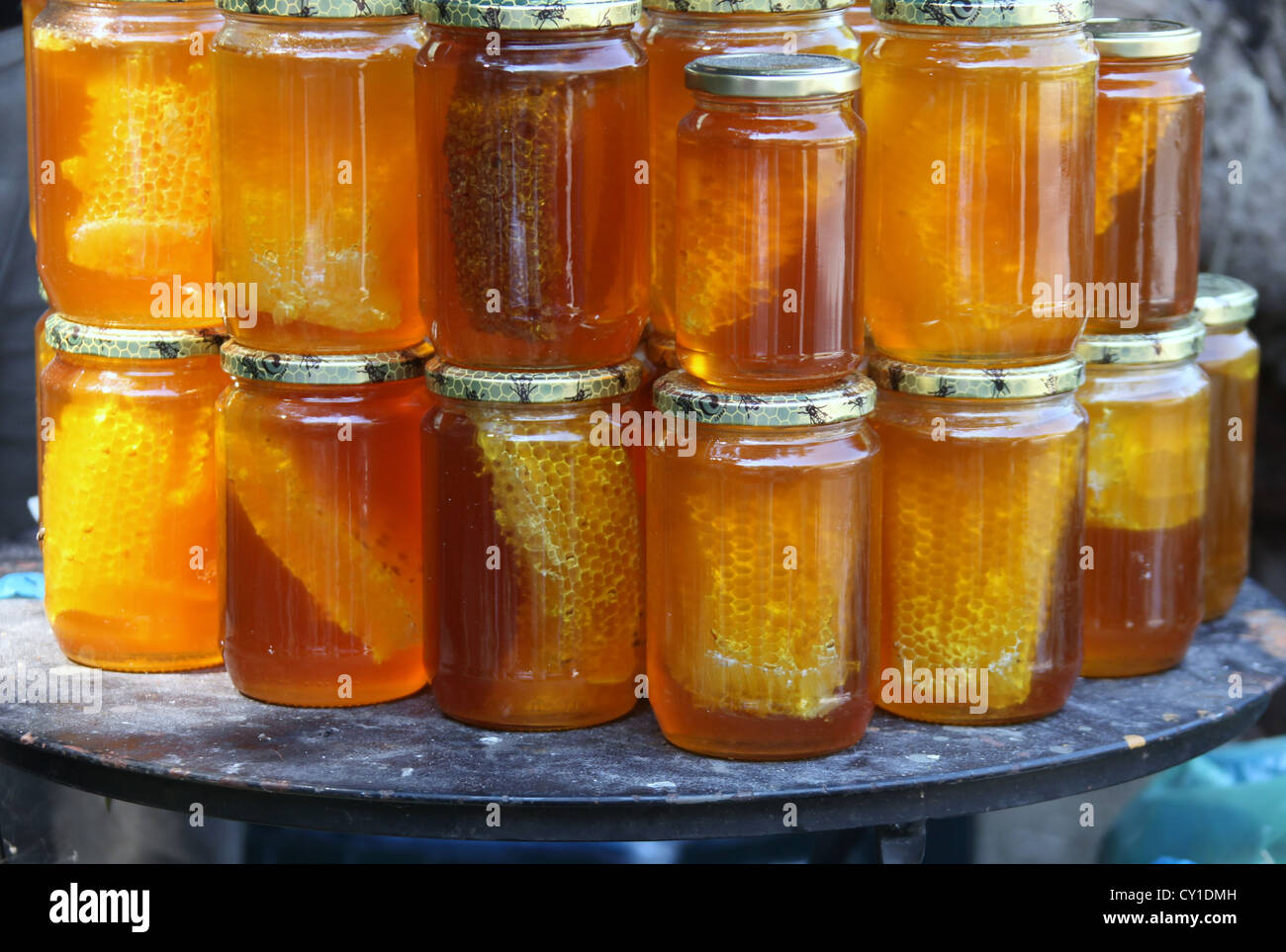 Panal con abejas y frasco de miel en mesa Fotografía de stock - Alamy