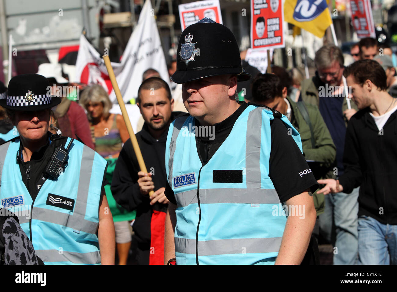 Oficiales de enlace de la policía vestidos de nueva luz azul chaquetas de alta vis y mezclarse con los manifestantes durante una protesta en Brighton, Sussex. Foto de stock