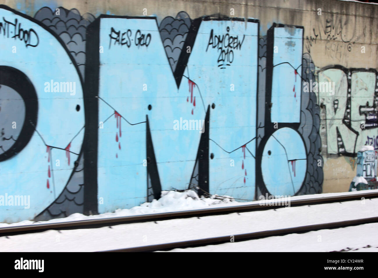 Coloridos murales de graffiti a lo largo de la estación de tren de invierno con nieve pistas, colorido, photoarkive Foto de stock