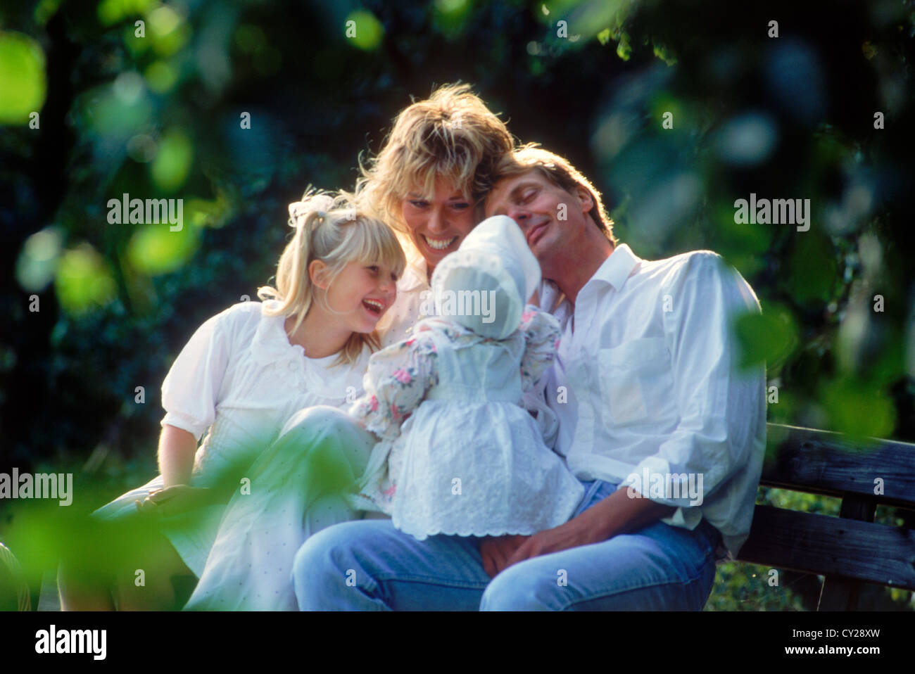 Una familia de cuatro, sentados y compartiendo el país en el banco de Suecia Foto de stock