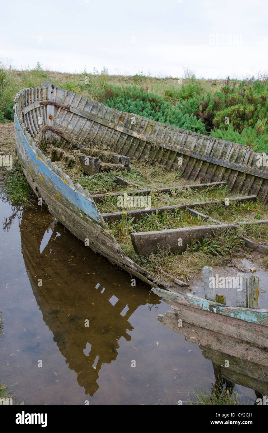 Naufragio de clínker construyó una barca de madera en la marisma salada costera, al norte de Norfolk, Inglaterra Foto de stock