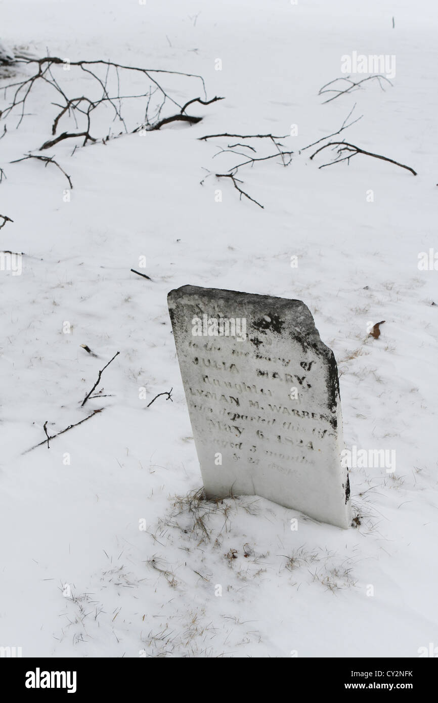 Una lápida en la nieve a la Pointe cementerio indígena en Madeline Isla. Foto de stock