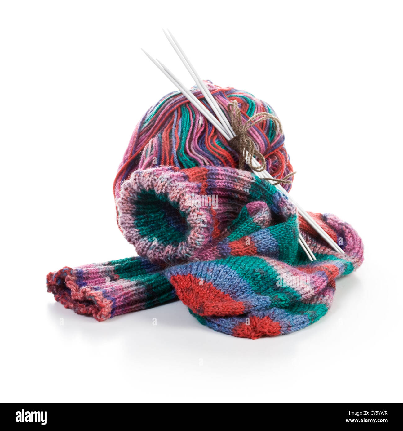 Calcetines multicolores, aguja de tejer y ovillo de lana sobre fondo blanco. Foto de stock