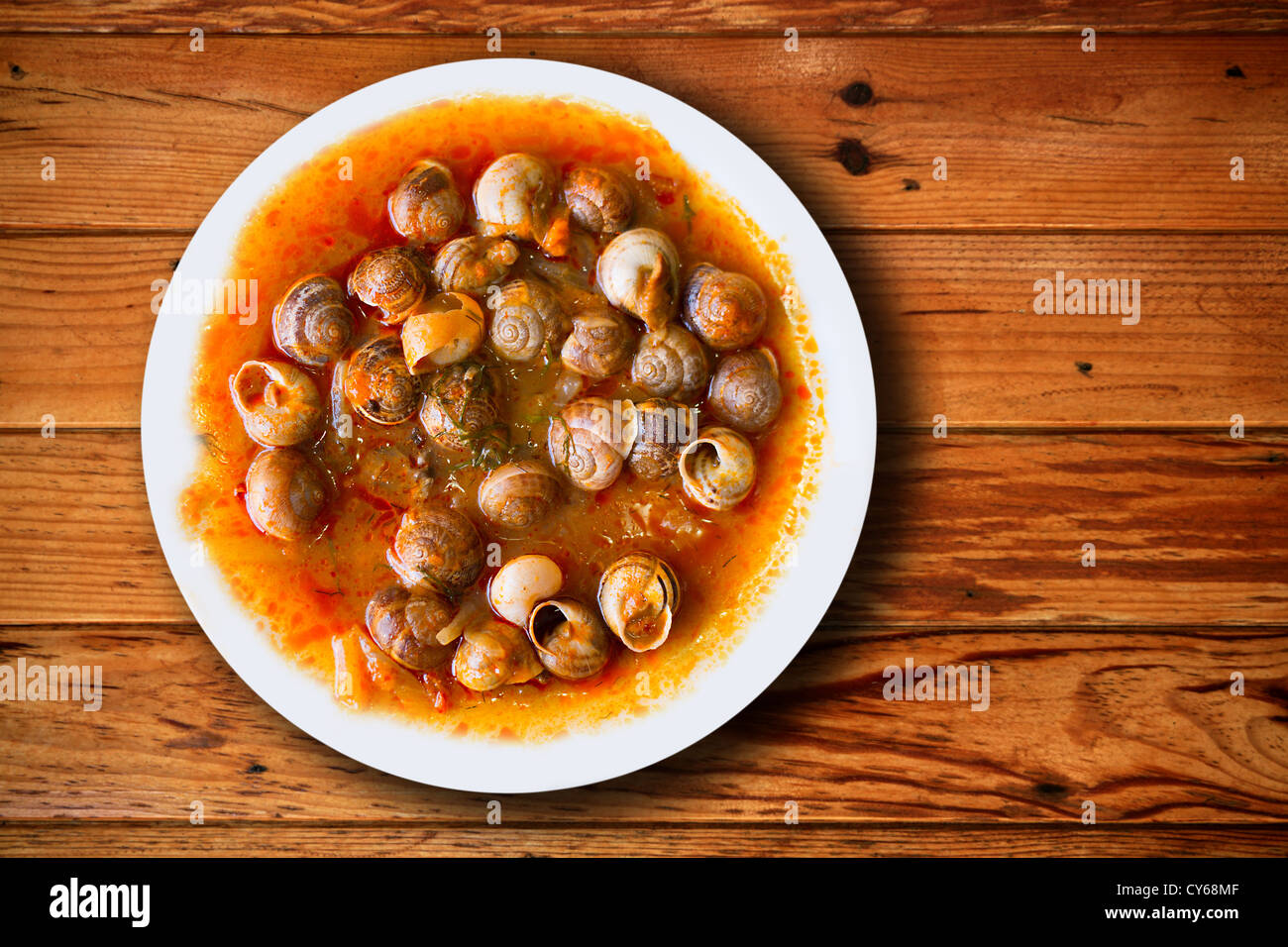 Plato de caracoles preparados al estilo tradicional mediterráneo español Foto de stock