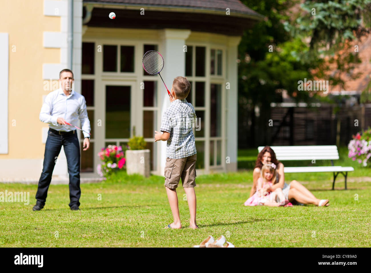 Joven familia feliz - los niños y los padres jugando en la pradera Foto de stock
