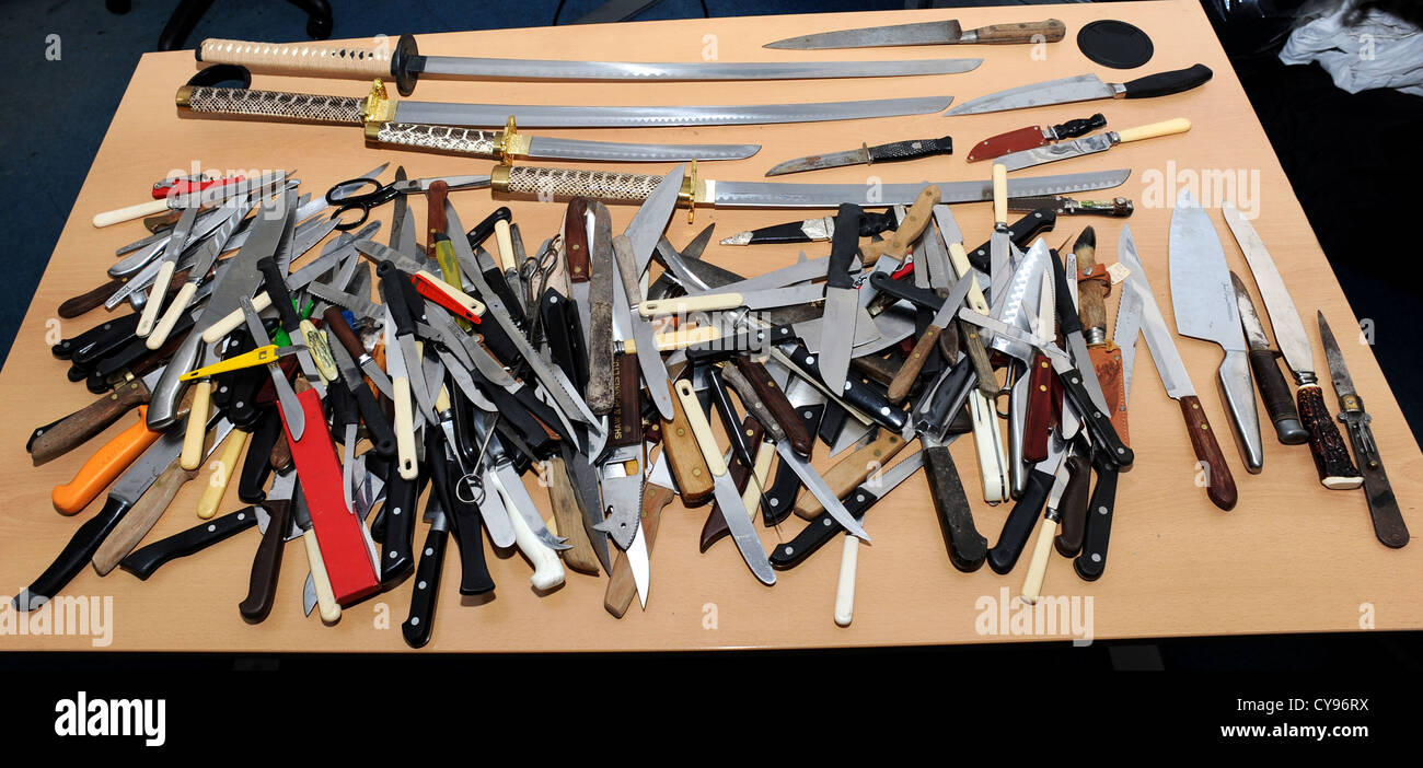 Mesa llena de cuchillos y espadas recogidas por la policía de Sussex tras una amnistía de cuchillas Foto de stock