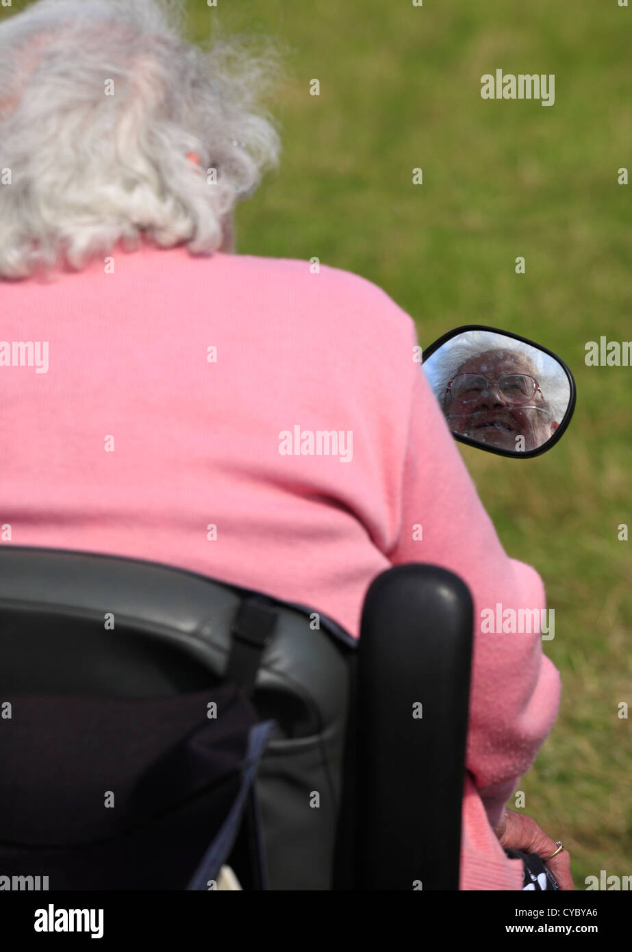 Una anciana sentada en un scooter de movilidad. Foto de stock