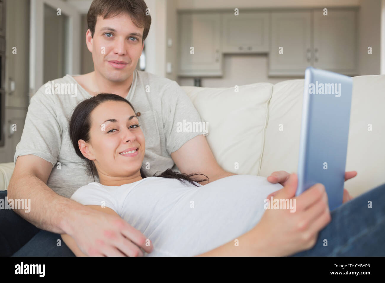 Los futuros padres utilizando el ebook y relajante Foto de stock