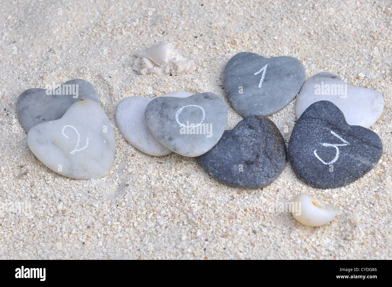 Cuatro corazones de piedra con 2013 inscripción en la arena Foto de stock
